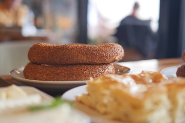 İki simit ekmek bir tabağa oturmuş, altın kabuklarını parlaklaştırıyor..