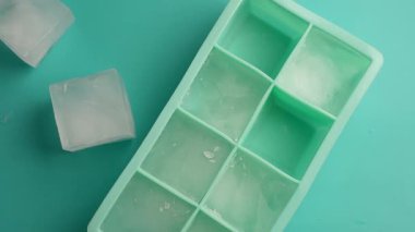 Buz küpleri parlak bir yüzeye yerleştirilmiş bir tepside erimeye başlar..