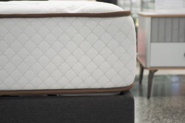 Gösterişli mobilyalarda sergilenen lüks bir yatağın yakın görüntüsü.