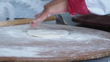 Yetenekli bir birey ahşap bir yüzeyde özenle hamuru şekillendirir..