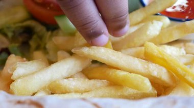 Bir el taze sebze ve sosun yanında altın kızartmalara uzanır..