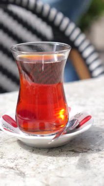 Sıcak Türk çayı güneşli bir terasta bir bardakta servis edilir..
