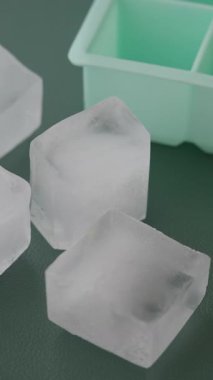 Temiz buz küpleri düz bir yüzeyde bir buz tepsisinin yanına yerleştirilir..