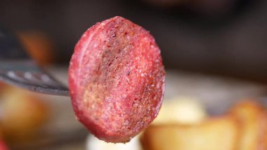 Çatalla servis edilen kıtır sosisin tadını çıkar..