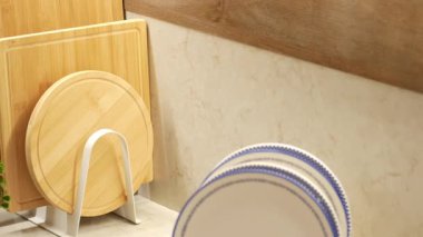 Ahşap kesme tahtaları ve dekoratif tabaklar mutfak düzeninde hizalanır..