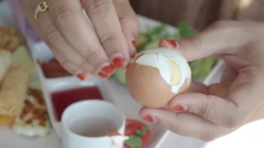 Eller, nefis bir kahvaltı deneyimi için rafadan yumurta hazırlar..