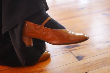 Parlak ahşap bir zemine takılmış şık kahverengi bir ayakkabının yakın çekimi..