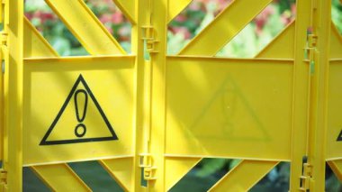 Açık hava ortamında parlak sarı uyarı işaretleri potansiyel tehlikeleri gösteriyor..