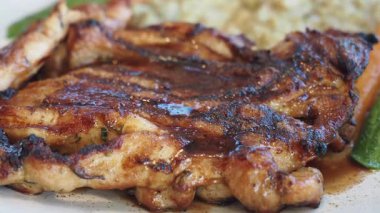 Baharatlı pirinç ve taze sebzeyle servis edilen ızgara tavuk..