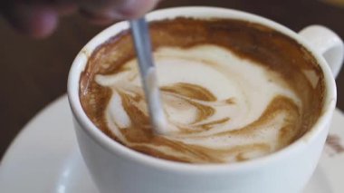 Barista cappuccino 'da güzel kıvrımlı desenler yaratır..