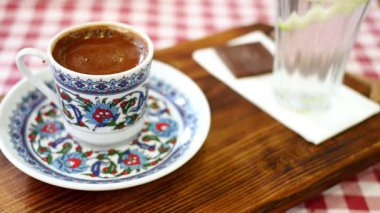 Sıcak bir kafede dekoratif bir tabakta Türk kahvesinin tadını çıkarıyorum.,