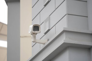 Gri binanın dış tarafına bir güvenlik kamerası yerleştirildi..