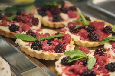 Taze böğürtlenli turtalar nane yapraklarıyla güzelce düzenlenir, eğlenmeye hazırdırlar..