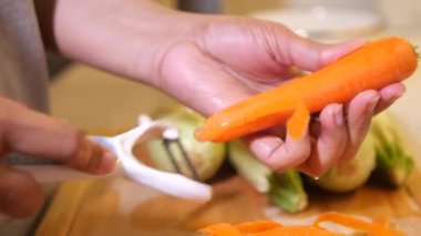 Eller, mutfakta havuç soyma işlemini etkili bir şekilde gösterir..