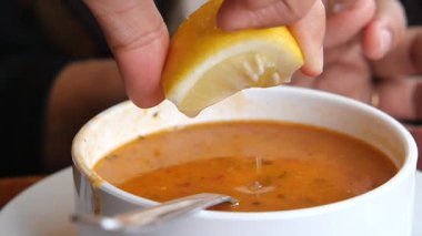 Taze limon, lezzet katmak için zengin bir kase çorbaya sıkıştırılır..