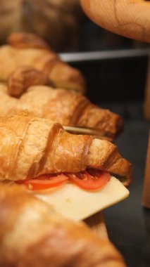 Kahvaltıda peynirli ve domatesli sıcak kruvasanların tadını çıkar..