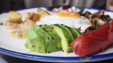 Yumurta, avokado ve sosis içeren lezzetli bir kahvaltının tadını çıkarın..