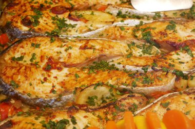 Taze otlar ve renkli sebzelerle servis edilen lezzetli ızgara balıklar..