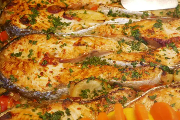 Taze otlar ve renkli sebzelerle servis edilen lezzetli ızgara balıklar..