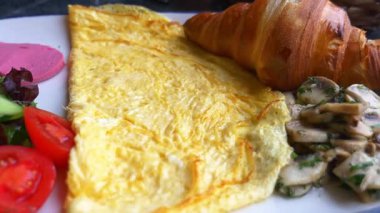 Omlet, kruvasan ve sebzeli lezzetli bir kahvaltının tadını çıkarın..