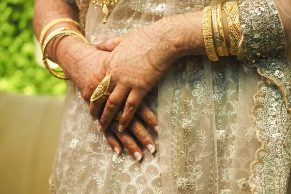 Kına ve altın mücevherlerle süslenmiş eller. Kültürel zarafet..