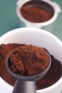 Kahverengi kahve telveleri bir mutfak ortamındaki ölçü kepçesini doldurur..
