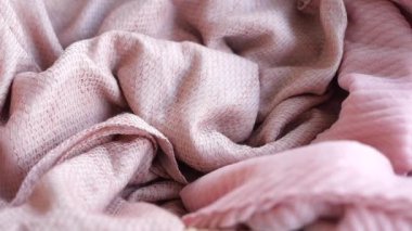 Nazikçe buruşmuş yumuşak pembe kumaşın davetkar dokusu ile yakın plan çekimi..