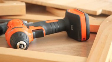 Bir kişi ahşap çerçeveyi çalışma yüzeyinde araçlarla birleştirir.