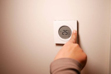 Bir kişi termostatı rahatlık için 25 dereceye ayarlar..