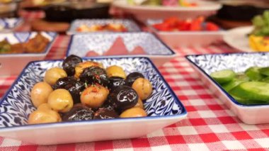 Kareli masa örtüsü üzerinde canlı bir aperatif dizisi..