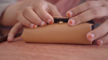 Biri yakınlarda el kol hareketi yaparken cüzdan masanın üzerine konur..