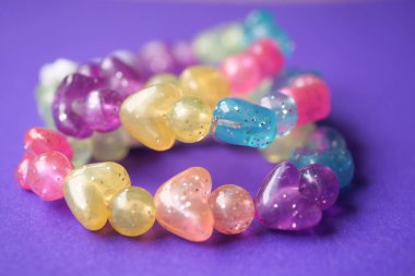 Yaratıcı bir şekilde gösterilen çeşitli renklerde canlı kalp şeklinde boncuklar..