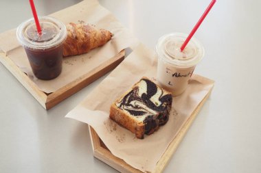 Taze demlenmiş kahve ve pişmiş yiyecekler ahşap tepsilerde servis edilir..