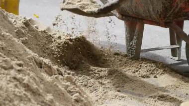 İşçiler inşaat işleri için kum ve el arabası kullanıyorlar.
