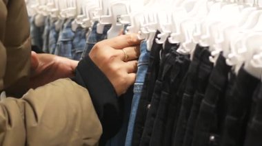 Perakende giyim mağazasında kot pantolon seçeneklerini araştırıyor.