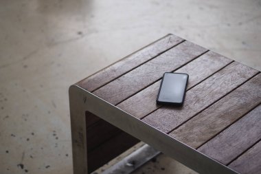 Parktaki bankta modern cep telefonu, akıllı telefon kavramını kaybetmiş. ,