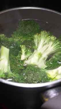 Parlak renk ve besinleri korumak için taze brokoli kaynatılıyor..