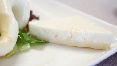 Yerel bir kafede taze yeşillikle servis edilen lezzetli peynir..