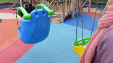 Çocuklar açık havada neşeli bir oyun bahçesinde oynayıp eğleniyorlar..