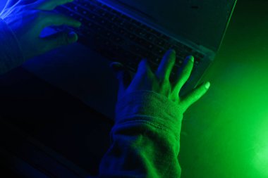 Sönük bir odada klavyeye yazı yazan eller, siber suç kavramı. .