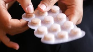 İnsan iyileşmek için su toplayan bir paketten ilaç almaya hazırlanır..