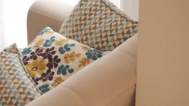 Şık oturma odasında kanepede zarif dekoratif yastıklar var..