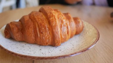 Bir kafedeki dekoratif tabağa taze pişmiş kruvasan..
