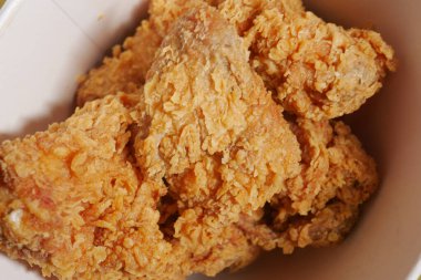 Pakette altın sarısı kızarmış tavuk parçaları var..