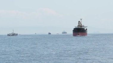 Çok sayıda gemi temiz bir gökyüzünün altında suyun üzerinde sorunsuzca ilerler..