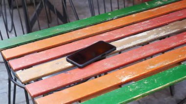 Kafedeki renkli ahşap bir masada dinlenen akıllı telefon. Akıllı telefon kavramını kaybettim .