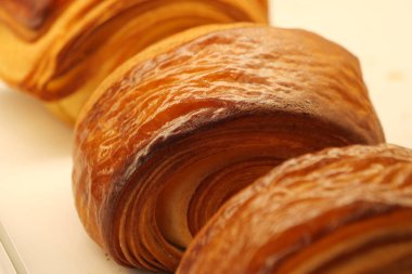 Sergilenen kruvasanlar, tabakalarını ve altın kabuklarını vurguluyor..