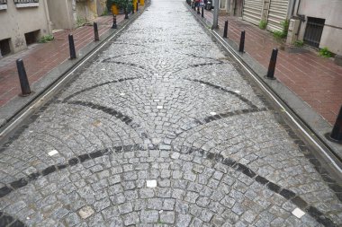 Paved yolu şehir ortamında karmaşık kaldırım taşı tasarımı sergiler.