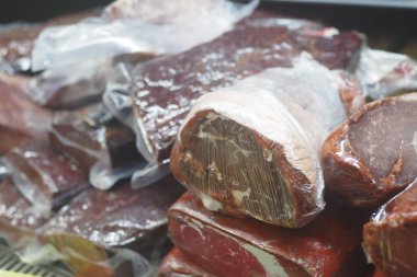 Elektrik süpürgesiyle paketlenmiş çeşitli et kesikleri dükkanda satılmaya hazır..