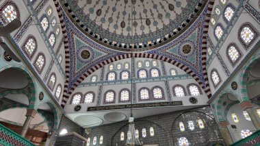 Bir caminin içinde ayrıntılı sanat eserleri ve renkli vitraylar sergilenmektedir..